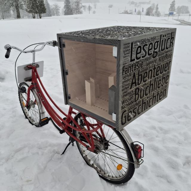 Fahrrad mit Bücherkiste im Schnee