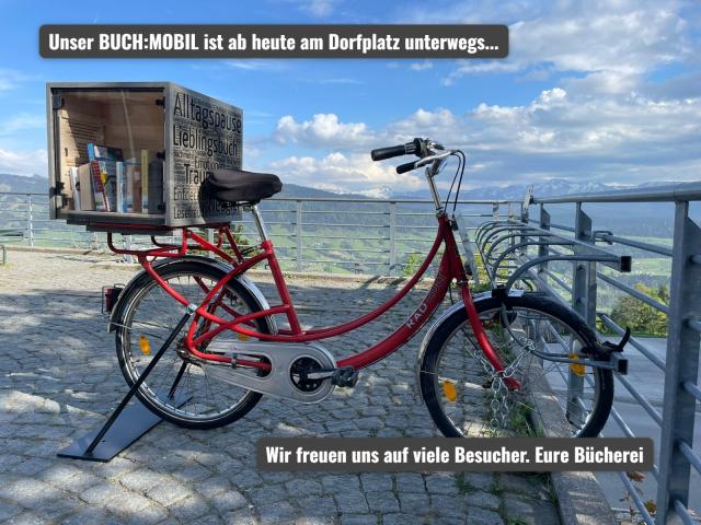 Fahrrad mit Bücherkiste auf dem Dorfplatz Sulzberg