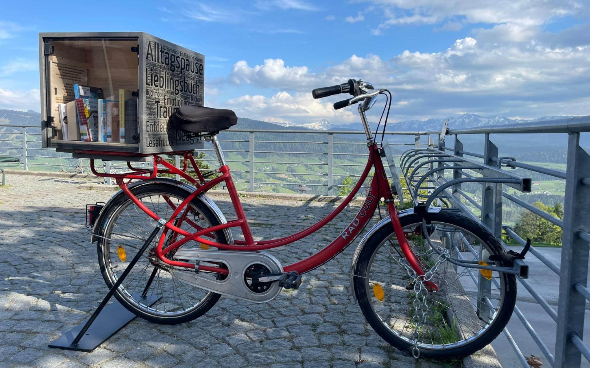 Fahrrad mit Bücherkiste auf dem Dorfplatz Sulzberg
